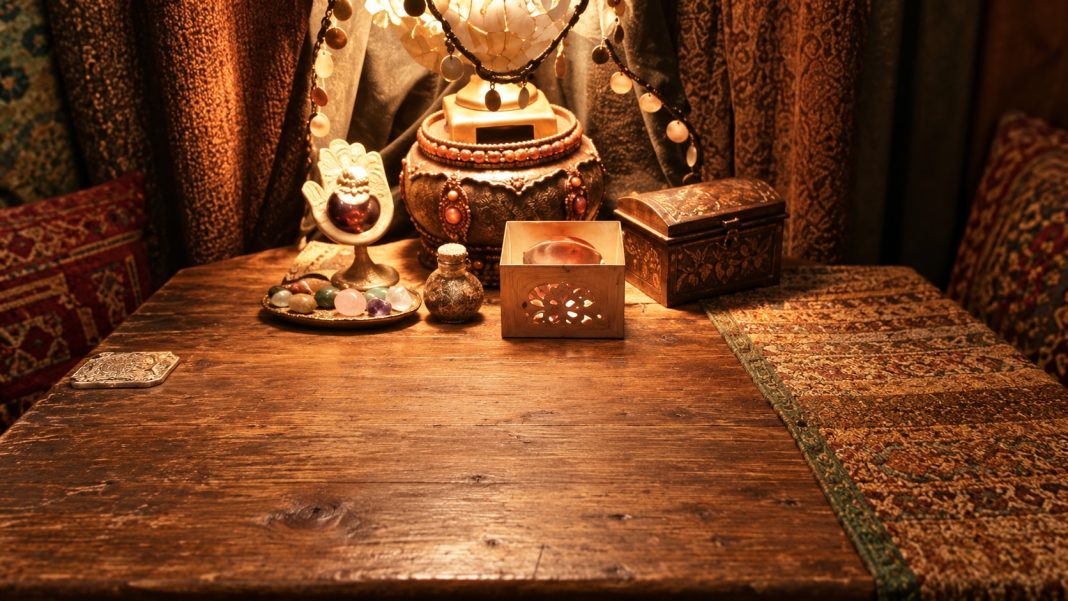 Reading corner photo repaired Modest curtain-lined home reading table with a lamp, small decorative objects and wooden boxes.